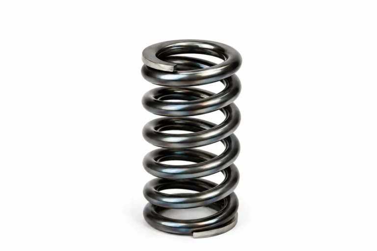 Helical compression spring in bright spring steel showing the ground ends and coil geometry used to explain fatigue, buckling, spring surge and compression spring design.