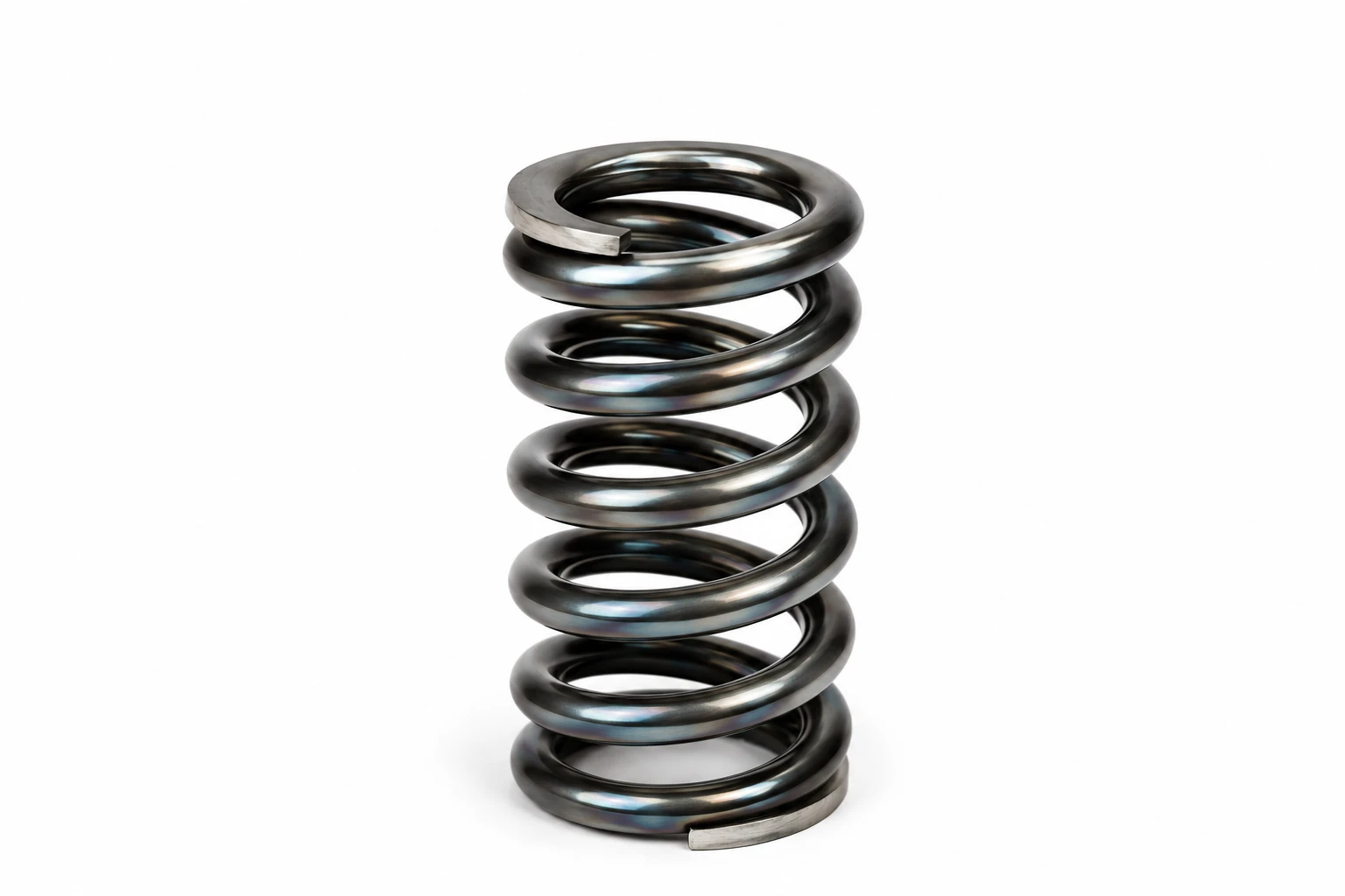 Helical compression spring in bright spring steel showing the ground ends and coil geometry used to explain fatigue, buckling, spring surge and compression spring design.