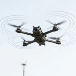 Modern counter-drone detection tower with radar panel, EO IR camera gimbal, and acoustic microphone array.